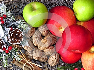 A pile of autumn fruit top view on brass table background. Green red apples, walnuts and a bunch of cinnamon . Rustic style photo.