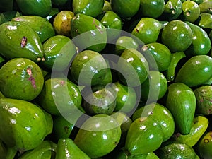 a pile of avocados on a market table