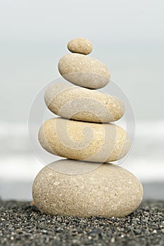 Pile of balanced rocks on black sandy beach photo