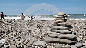 Pile of balanced rocks on the rocky shore of a beach