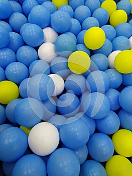 Pile of balls . Blue ball . White ball . Yellow ball . Kids play zone . Ball background . Fun background