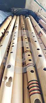 A pile of bamboo flutes, a musical instrument that is sounded by blowing