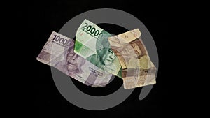 Pile of banknotes. Rupiah currency isolated on a black background.