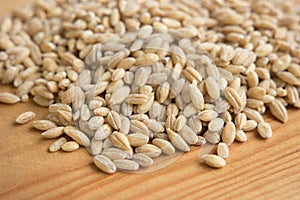 Pile of barley pearl in wooden background.