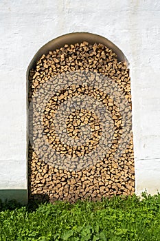 A pile of birch firewood in the wall of the Spaso-Yakovlevsky monastery in the city of Rostov, Yaroslavl region