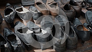 A pile of black and brown used leather shoes