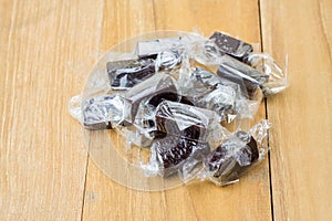 Pile black candy on wooden board