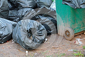 Pile black garbage bag roadside in the city close up