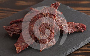 Pile of Black Pepper Beef Jerky on a Rustic Wooden Table