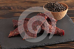 Pile of Black Pepper Beef Jerky on a Rustic Wooden Table