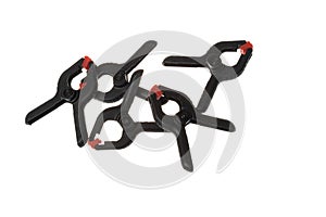 Pile of black plastic clamps with red tips, isolated on white background