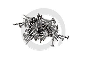 A pile of black steel screws isolated on a white background close up.