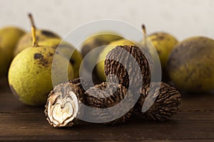 A pile of black walnut Juglans nigra lies on a wooden table. Useful nuts with a hard shell