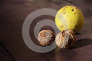 A pile of black walnut Juglans nigra lies on a wooden table. Useful nuts with a hard shell