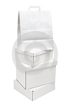 Pile of blank white paper boxes and paper bag packages isolated on white background