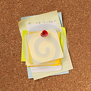 Pile of blank yellow notes stacked and pinned with a red tack. Empty copy space for important office notice, message, or reminder