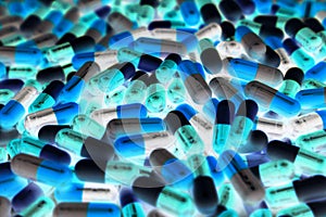 Pile of blue, green, and white color of capsule pills with modern design light. Toxicology medicine concept. Pharmaceutical. photo