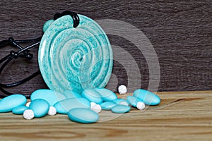 Pile of blue stones with decorative amulet on wooden table, sample for postcard or greeting card