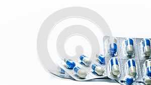 Pile of blue, white capsule pills in blister pack isolated on white background with copy space. Global healthcare
