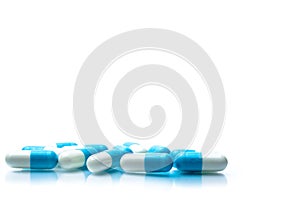 Pile of blue and white capsules pills isolated on white background with shadows and copy space for text.
