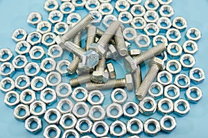 Pile of bolts and nuts on a blue background. Background with nuts and bolts.