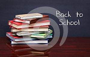 Pile of books on the desk. The words 'Back to School' written