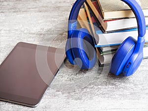 Pile of books with headphones on the table