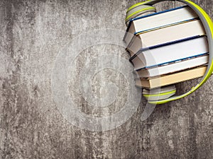 Pile of books with headphones. Top view