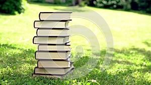 Pile of books standing on the grass on the meadow outddors
