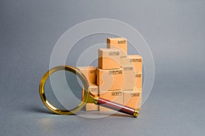 A pile of boxes and a magnifying glass. Concept search for goods and services. Tracking parcels. Quality control. Search