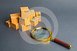 A pile of boxes and a magnifying glass. Concept search for goods and services. Tracking parcels via the Internet. Quality control