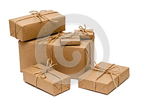 Pile of boxes wrapped with brown kraft paper and tied with twine on a white background. Delivery, moving, gifts concept