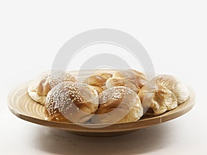 The pile of breads in the wooden dish.