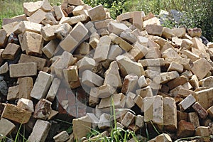 Pile of bricks by an old brick wall taken by an old building in on one of the city streets photo