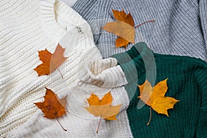 A pile of bright autumn leaves on a textile knitted background of plaid and sweaters