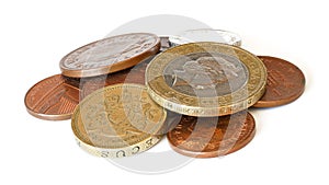 Pile of British coins - pounds and pennies, closeup detail isolated on white background