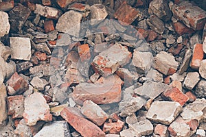 Pile of broken bricks, background. Texture, pattern, brick wall collapse. Destruction surface of building`s facade. Debris.