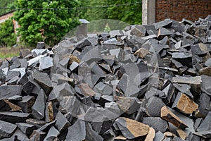 Pile of broken granite stones. Many pieces of broken stone. Wastes from the production of granite products