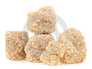 Pile of brown cane sugar pieces isolated on white background. Unrefined demerara