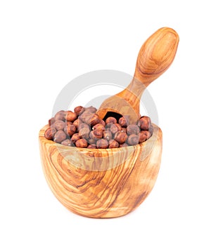 Pile of brown chickpeas in olive bowl and scoop, isolated on white background. Brown chickpea. Garbanzo, bengal gram or