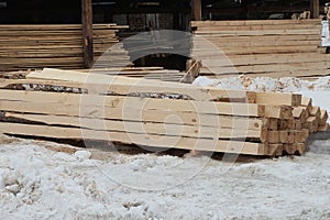 A pile of brown long wooden planks and beams