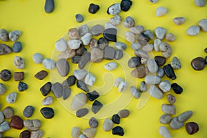 A pile of brown pebbles on yellow background