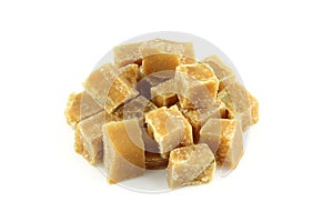 Pile of brown sugar cubes isolated on white background. Walnut nd milk fudge stack