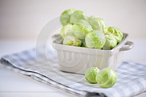 A pile of Brussels sprouts in a bowl on the light background close up
