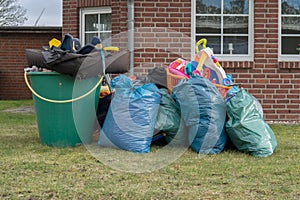 Pile of bulky waste in front of a house with garbage bags