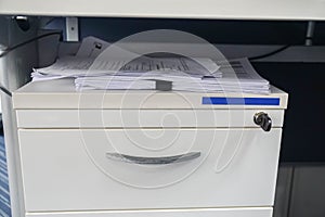 Pile of business documents in paper clip on office cabinet
