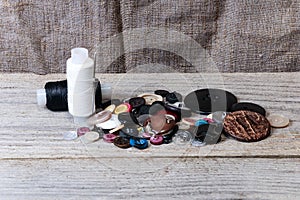 Pile of buttons, black and white thread, needle