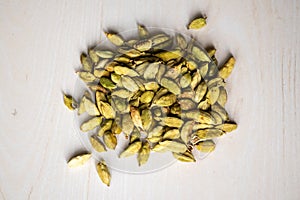 A pile of cardamom pods isolated on a wooden background. locally in Bangladesh, it is called Elachi photo