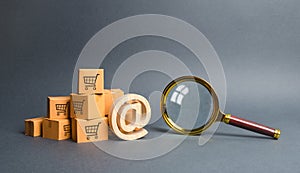 Pile of cardboard boxes with email symbol commercial AT and magnifying glass. online shopping and commerce. Search engine