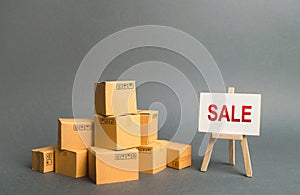 A pile of cardboard boxes and stand with the word sale. sale of products, discounts on goods of the outgoing season. commodity